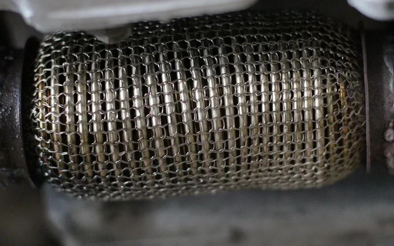 Mechanic inspecting a car's exhaust system during a repair