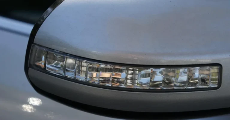 Close-up of the silver painted housing of a car side mirror with a turn signal