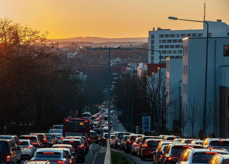 Slow stop-and-go traffic on a city road at sunset