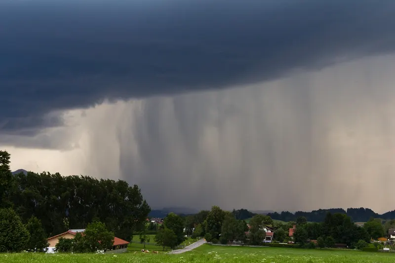 Dark storm cell with heavy rain over farmland