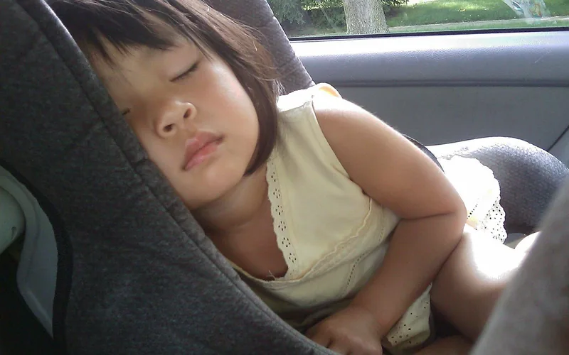 toddler securely buckled into a rear-facing car seat in the back seat of a car toddler securely buckled into a rear-facing car seat in the back seat of a car