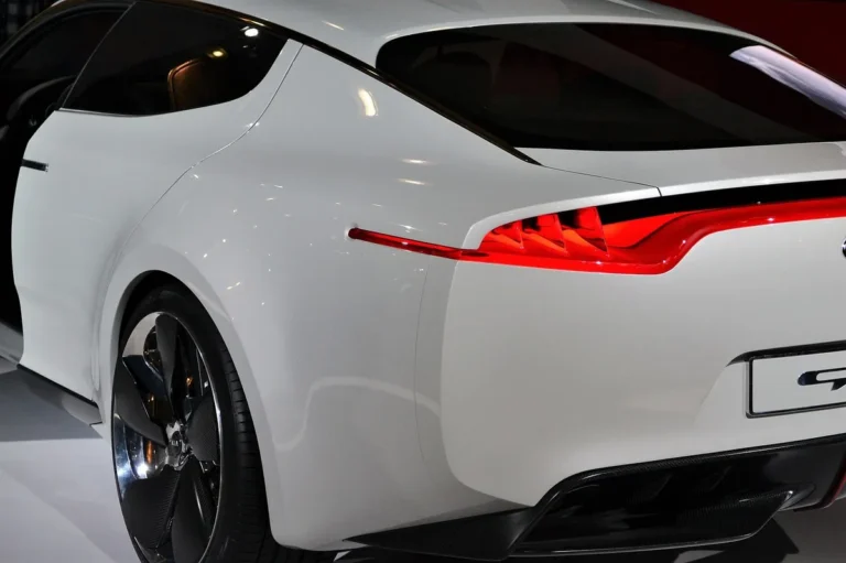 Rear quarter panel and tail light of a white car with glossy paint