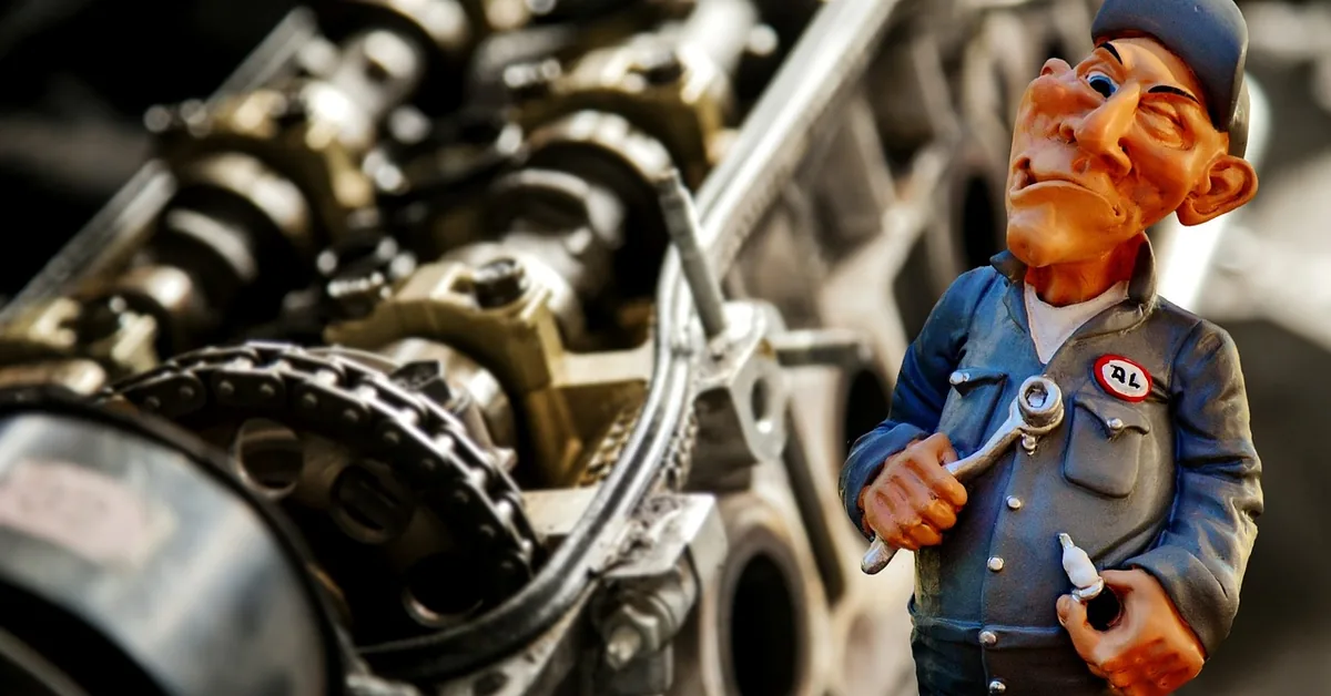 Mechanic using a wrench near a car engine bay to disconnect the battery terminal