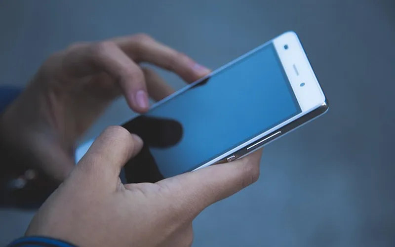 Hands using a mobile phone touchscreen