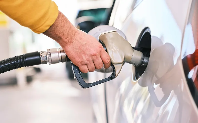 driver refueling a car with gasoline at a gas station pump