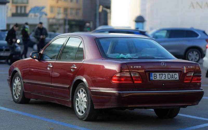 Row of rental sedans parked in a car rental agency lot