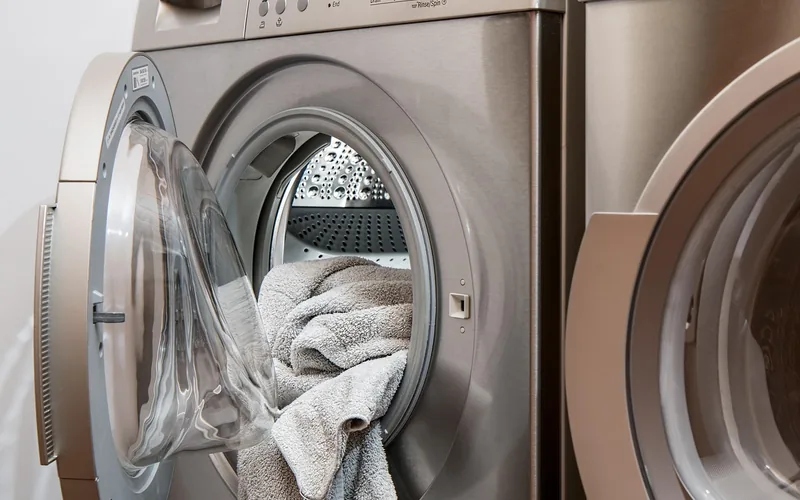 Front-load washing machine mid-cycle with a towel, illustrating a gentle cold-water wash