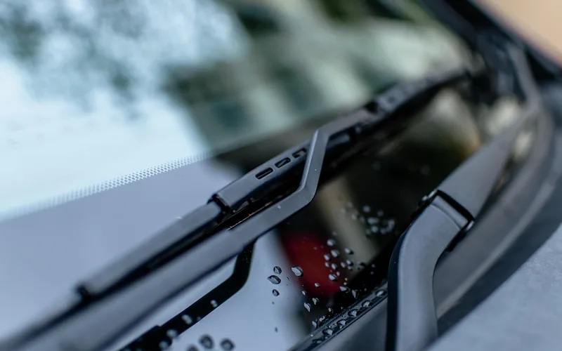 close-up of a windshield wiper blade resting on clean car glass