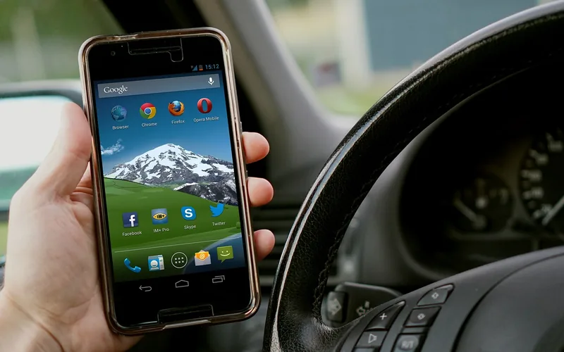 Android phone held beside a car steering wheel Android phone held beside a car steering wheel