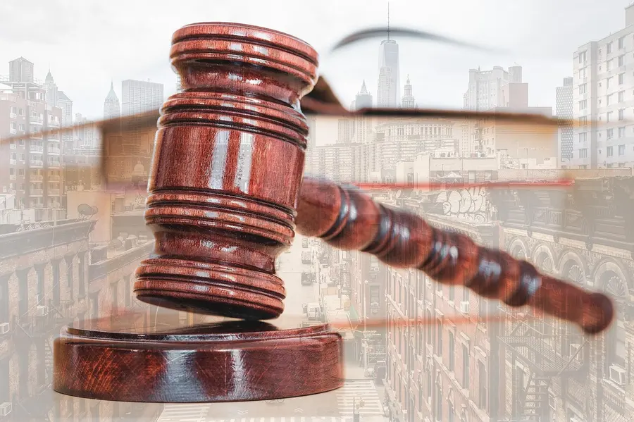 A wooden auction gavel on a sound block over a blurred city street
