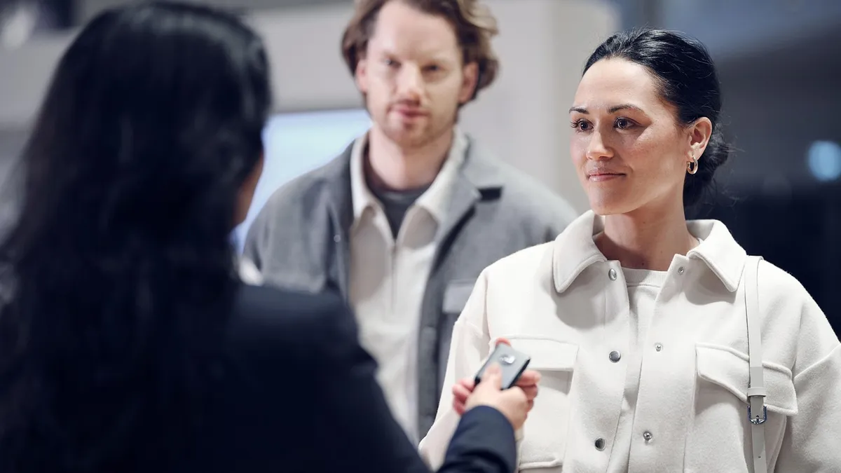 Car buyer receiving keys from a salesperson after negotiating the out-the-door price down from the dealer markup