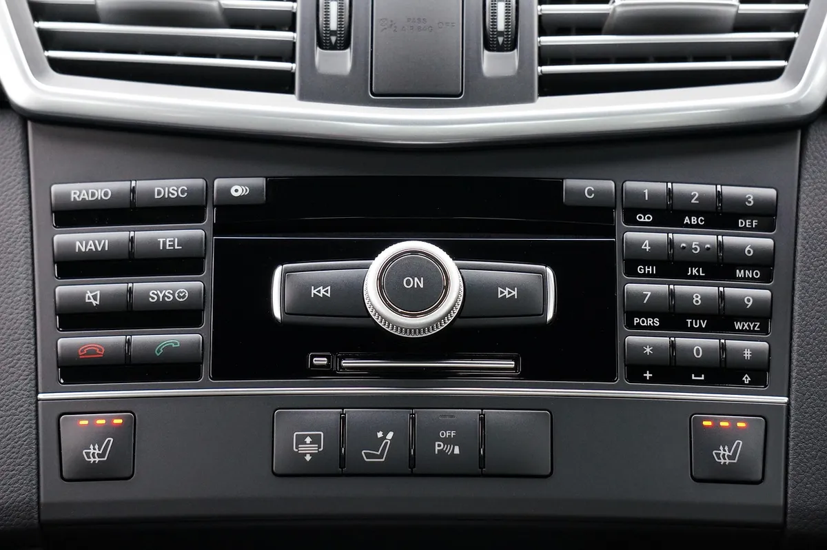 Car center console showing radio and CD control buttons and a knob below the air vents