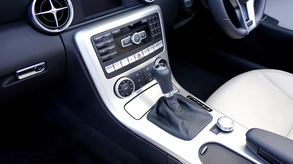 Car center console with a round climate dial and a dashboard air vent