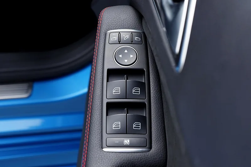 Window switch cluster on a black plastic car door panel
