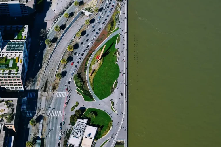 Aerial view of a city road with cars next to a waterfront