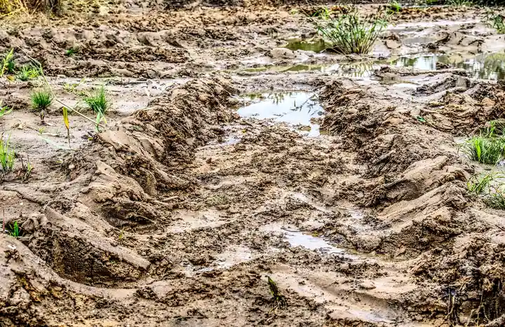 Deep wet mud ruts and puddles on a soft dirt track