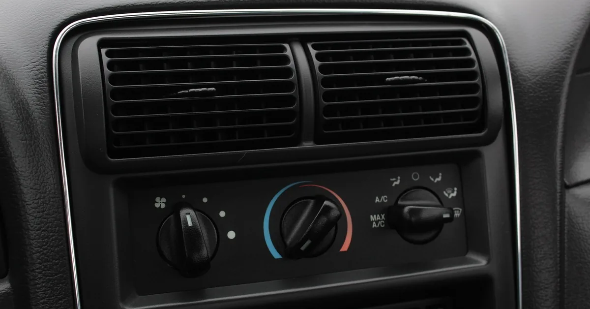 Close-up of a car dashboard air conditioning controls and vent buttons