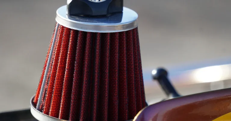 Red cone-style engine air filter with a black cap, close-up
