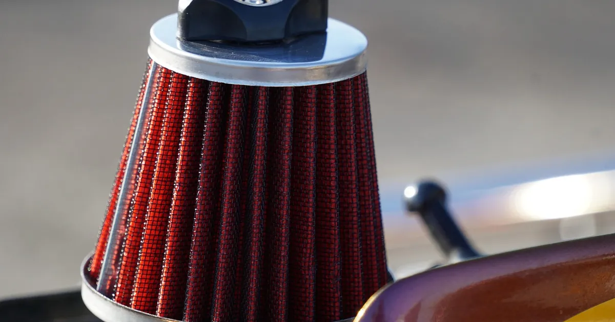 Red cone-style engine air filter with a black cap, close-up