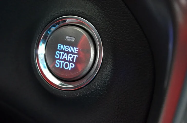 Illuminated Engine Start Stop push button set in a car dashboard trim