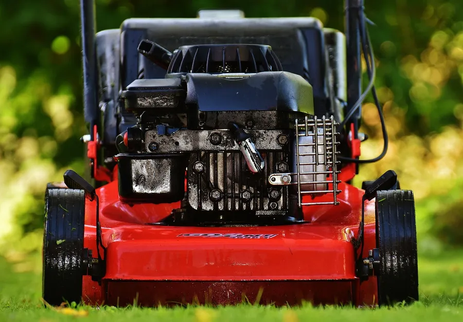 Front view of a red push lawn mower showing its small gasoline engine