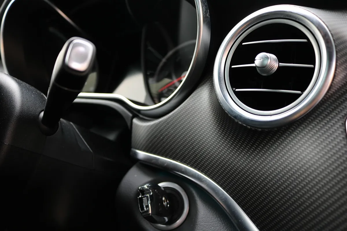 Round chrome-ringed air vent on a car dashboard