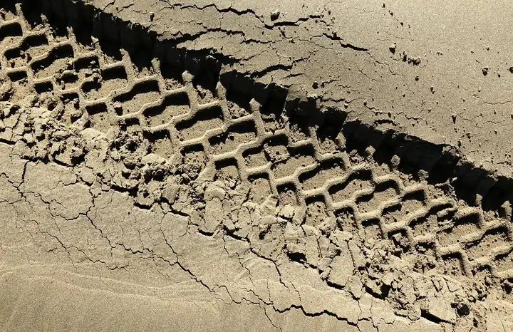 Tire tread imprint pressed into soft beach sand