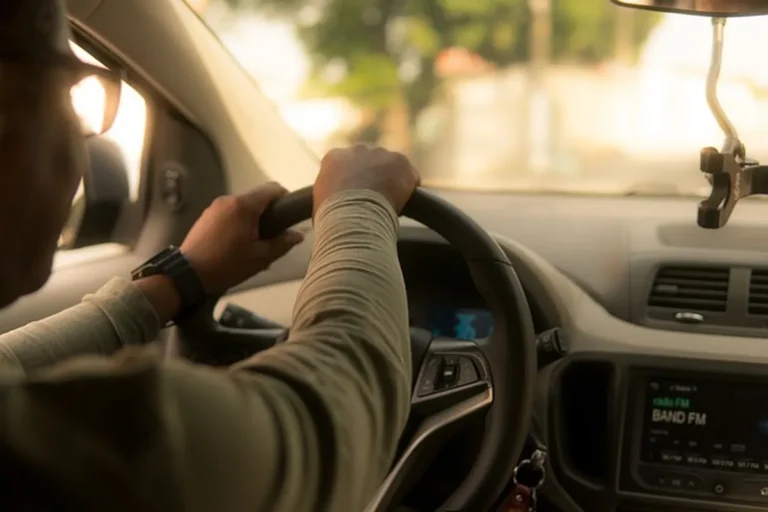 Driver with both hands on the steering wheel of a car