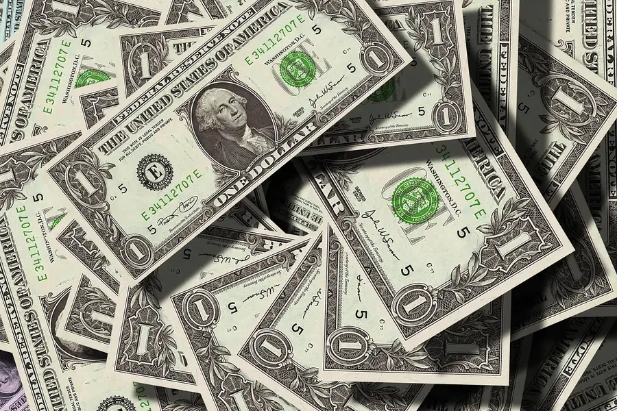 A pile of US one-dollar bills representing a cash payment A pile of US one-dollar bills representing a cash payment