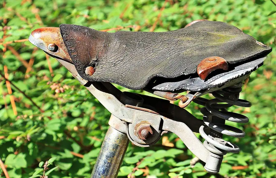Weathered leather with surface cracking on an old bicycle saddle