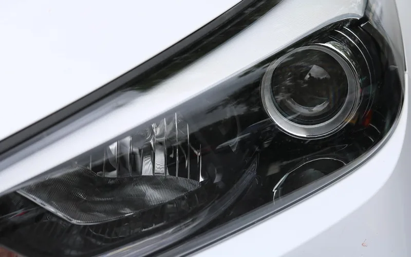 Close-up of a headlight assembly on a white car