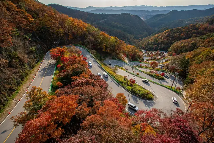 aerial view of a winding mountain road with cars driving