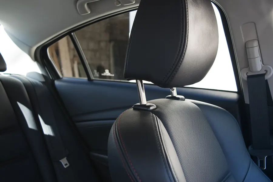 black perforated leather rear seat headrest with red stitching
