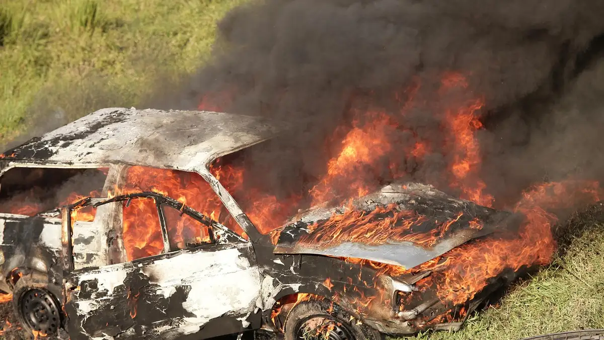 A burned-out vehicle wreck showing severe fire damage to the body