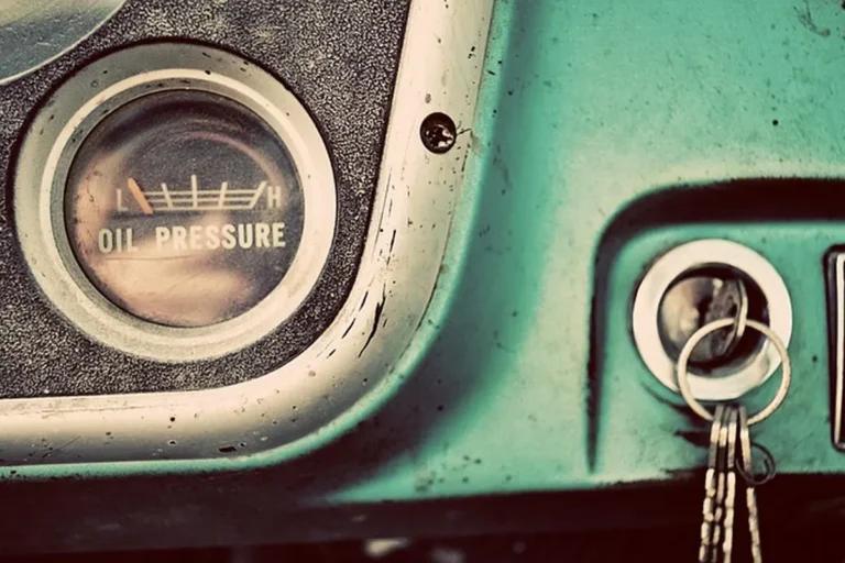 Car key with a key ring in the ignition of a vintage truck dashboard