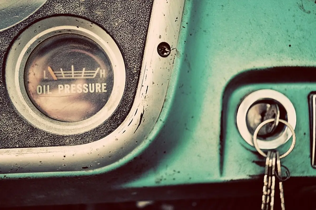 Car key with a key ring in the ignition of a vintage truck dashboard