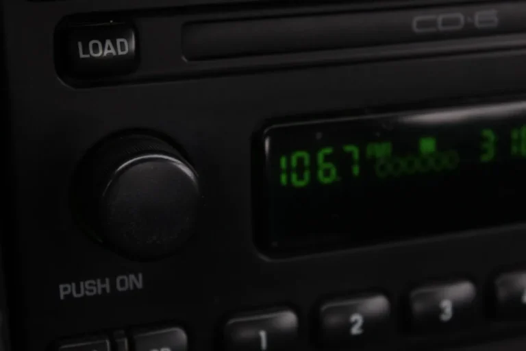 Car stereo head unit with a CD slot, load button and green radio display