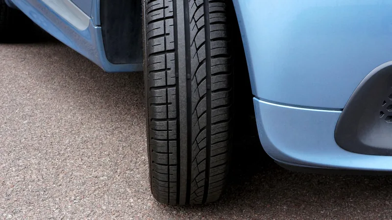 Close-up of a car tire on asphalt next to the wheel arch