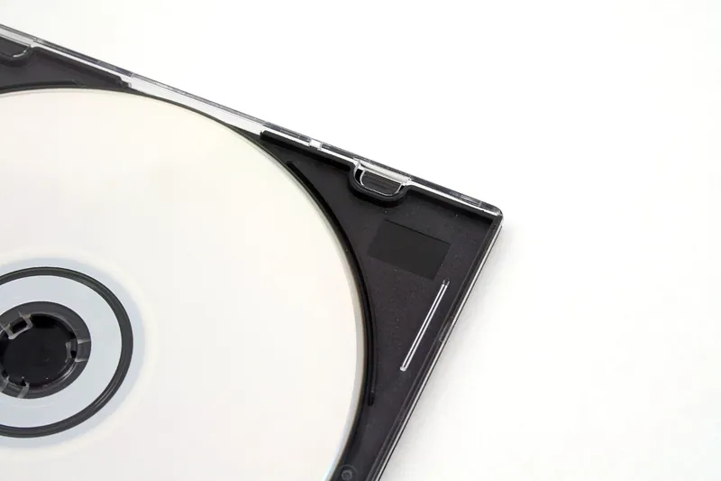 Compact disc sitting in a slimline plastic case on a white surface