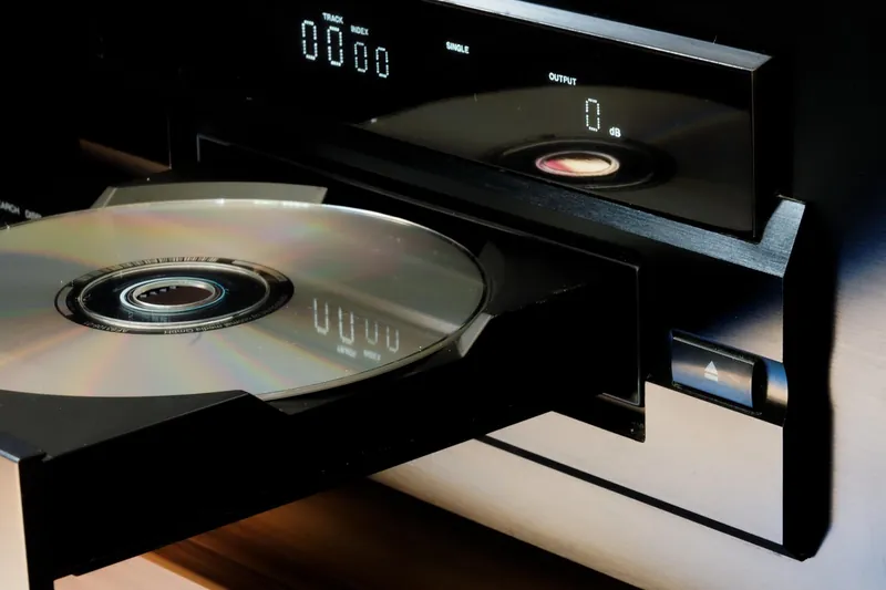 Compact disc resting on an open player tray beside the eject button
