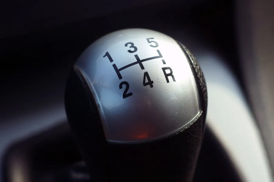 Manual transmission shift knob showing a five-speed pattern with reverse