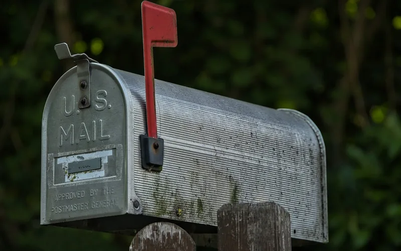 Metal rural mailbox with red flag raised