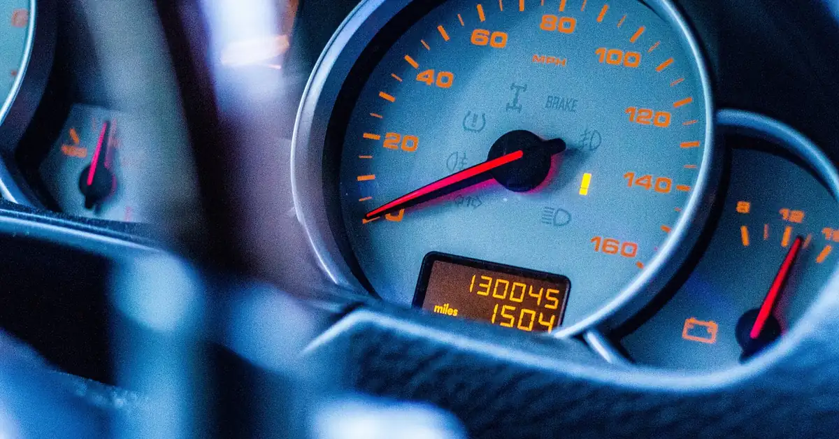 Car speedometer dashboard needle climbing toward high mph, illustrating top speed in racing games