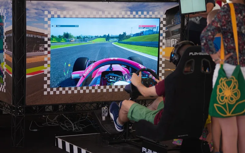 Player using a racing wheel and pedal simulator rig to practice cornering and handling technique Player using a racing wheel and pedal simulator rig to practice cornering and handling technique