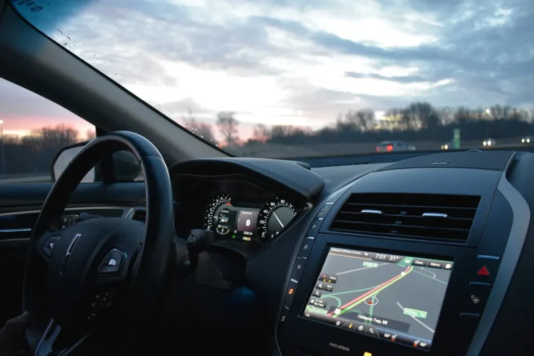 Car dashboard at dusk with a navigation map on the infotainment screen
