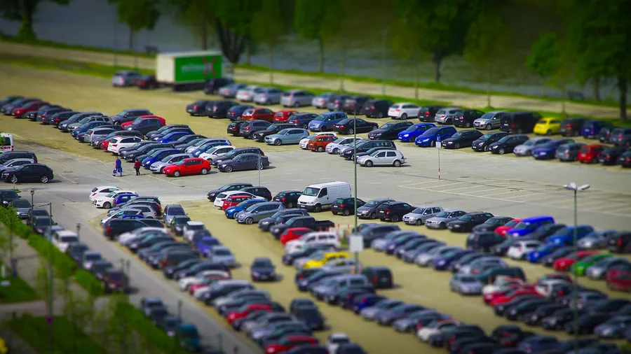 Aerial view of many cars parked in rows in a large parking lot