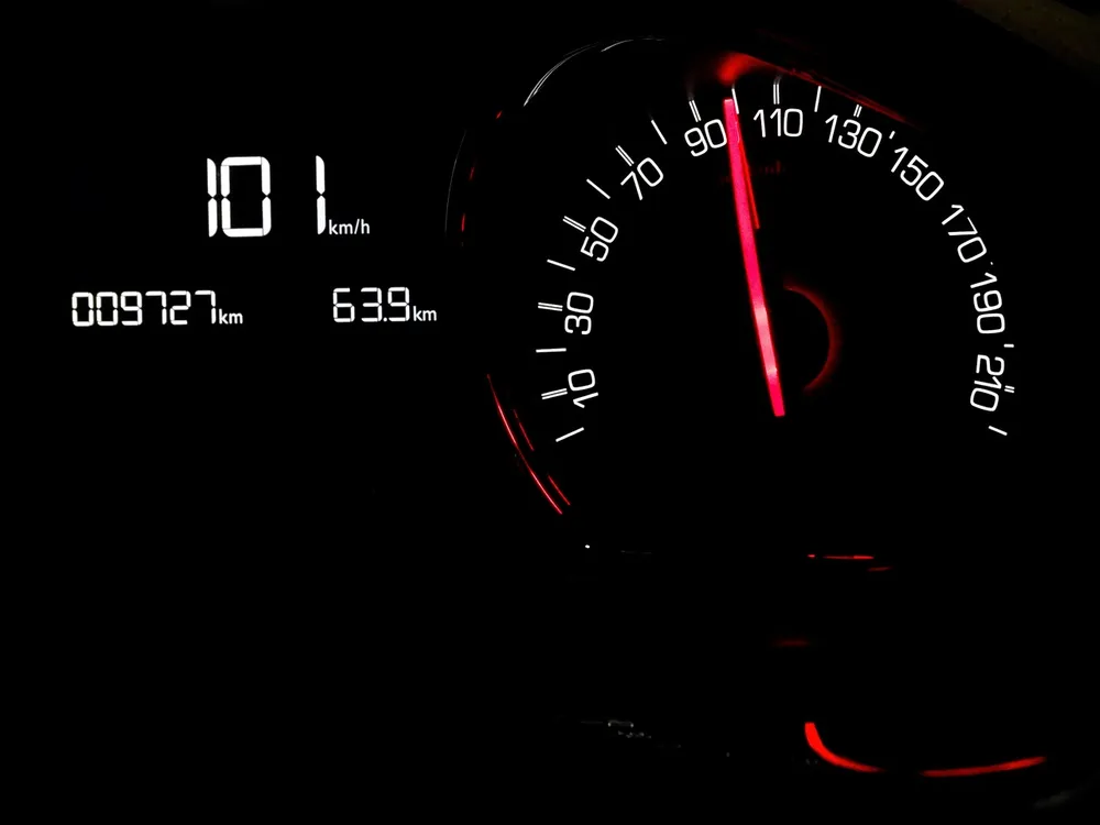 Dashboard speedometer display reading 101 km/h beside a red needle gauge
