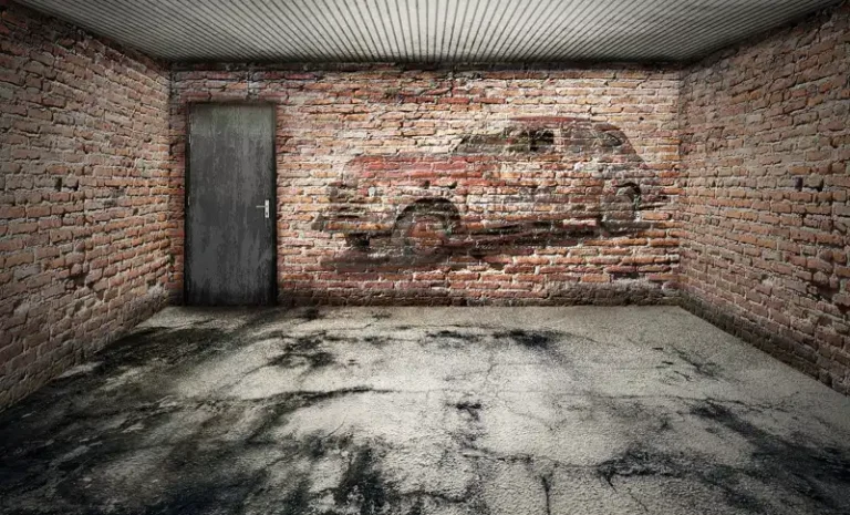 Empty brick-walled garage with a concrete floor and a metal door
