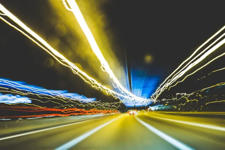 Streaks of blurred yellow and white light on a night road