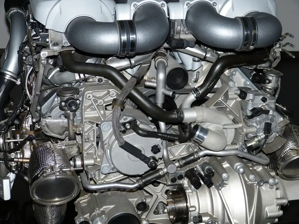 Twin-turbocharged piston engine on display with large intake pipes and black hoses